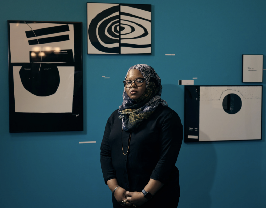 Kameelah Janan Rasheed standing in front of her art show "An Opening" at the Brooklyn Historical Society. 